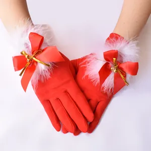 Guanti natalizi rossi da donna con pelliccia sintetica bianca, fiocco di raso rosso e campanelli dorati.
