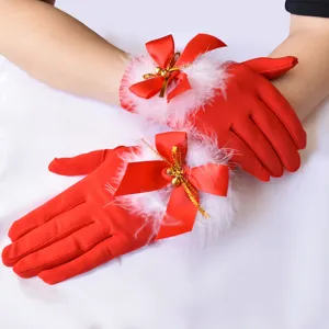 Vista dettagliata di guanti rossi natalizi da donna con piume bianche e campanelli dorati.