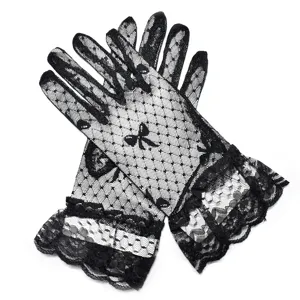 Nahaufnahme von schwarzen Spitzenhandschuhen mit Punkten, Schleifen und Rüschen für Damen.