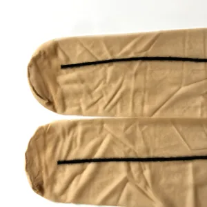 Detailaufnahme von hautfarbener Feinstrumpfhose mit elegantem schwarzem Rückennaht-Design.