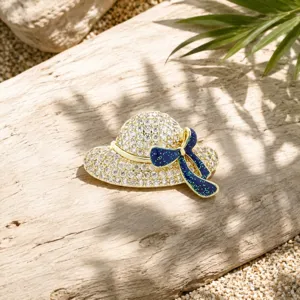 Elegante hoedvormige broche met sprankelende strass-steentjes en blauwe strik voor damesblazer.