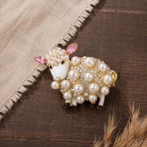 Detailed close-up of a charming sheep brooch decorated with pearls and sparkling crystals.