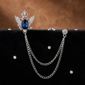 Detailansicht der Retro Krone Adler Brosche mit blauem Stein und doppelten Silberketten.