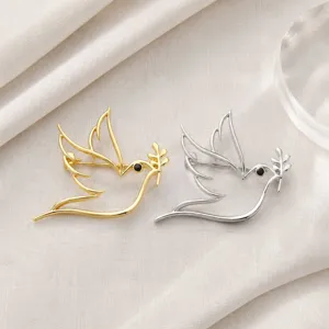 Detailed view of minimalist hollow peace dove brooch, elegant metal lapel pin clothing accessory.