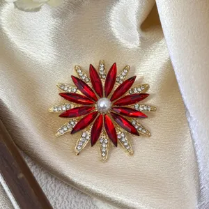 Nahaufnahme einer eleganten, roten Strass-Blumenbrosche mit einer zentralen Perle.