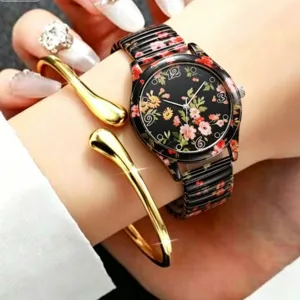 Detailopname van het elegante bloemige kwartshorloge gedragen om de pols met gouden armband.