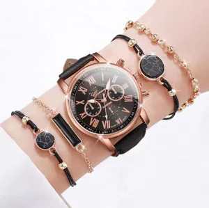 Primo piano di elegante orologio al quarzo in oro rosa e bracciali con pietra nera al polso.