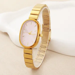 Elegant oval women's quartz watch with pink dial and gold tone metal strap detail view.