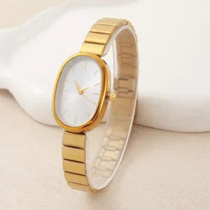 Detail close-up of the elegant gold oval dial quartz watch with metallic strap, stylish look.