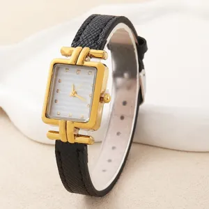 Nahaufnahme der Damenquarzuhr mit quadratischem Goldgehäuse und schwarzem Armband.
