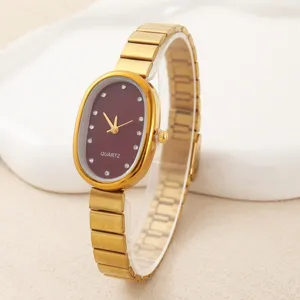 Elegant oval quartz watch with burgundy dial, crystal hour markers and gold metal strap.