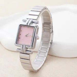 Detailopname van rechthoekige dames quartz horloge met roze wijzerplaat en zilveren band.
