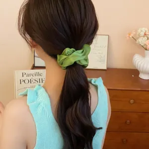 Detalle de coletero de satén verde con tejido de malla fina y elegante estilo de accesorio.
