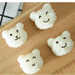 Detailed shot showing cute bear-shaped rice balls on a wooden board, perfect for bento decoration.