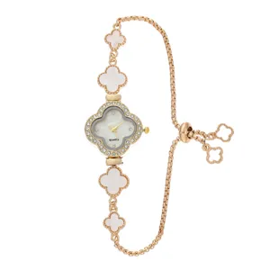 Women gold quartz watch with mother of pearl clover dial and rhinestone bezel accessory.