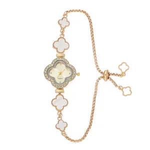 Close-up detail of the gold-tone clover quartz watch bracelet with sparkling rhinestones.