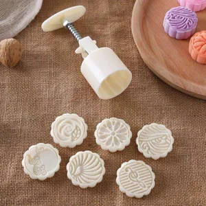 Vista dettagliata del set di stampi per mooncake con timbri intricati e manico a pressione.