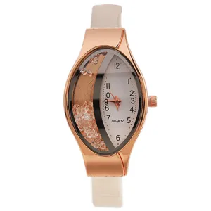 Dettaglio orologio donna al quarzo, cassa oro rosa ovale, quadrante cristalli, cinturino bianco.