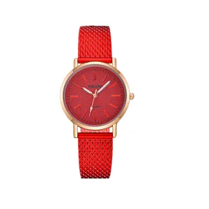 Primo piano dell'elegante orologio al quarzo con cinturino in maglia rossa e cassa dorata.
