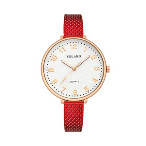Primo piano dettaglio di orologio donna al quarzo con cinturino maglia rosso, cassa oro rosa e quadrante.