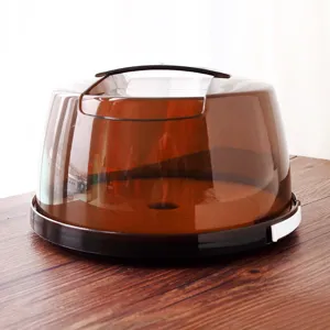 Vista dettagliata del coperchio per torta in plastica spessa con cupola traslucida marrone.