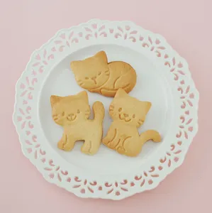 Schattige katvormige koekjes op een wit bord, perfect voor bakken en DIY-liefhebbers.