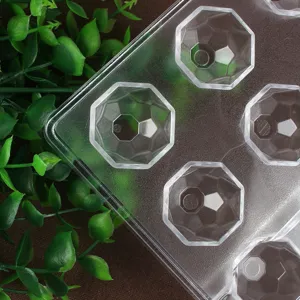 Gedetailleerd overzicht van doorzichtige plastic chocoladevorm met gefacetteerde holten.