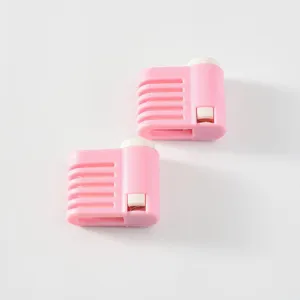 Gedetailleerd uitzicht op roze plastic taartsnijder en egaliseergereedschap met gleuven.