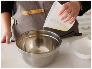 Siliconen maatbeker voor de keuken met duidelijke dubbele schaalverdeling en schenktuit.