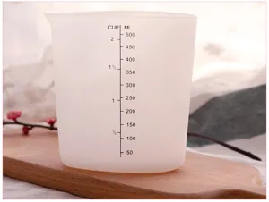 Gedetailleerd close-up van doorzichtige siliconen maatbeker met duidelijke ml- en cupschalen.