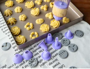 Vue detaillee de la presse a biscuits avec diverses douilles pour faconner des petits fours.