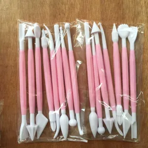 Detailed view of pink and white fondant cake carving tools in transparent bags for baking.