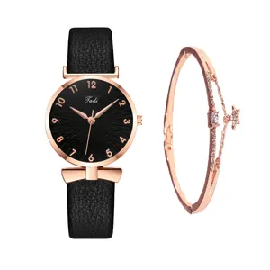 Set orologio al quarzo e bracciale da donna con cinturino in pelle nera e ciondolo a stella chic.
