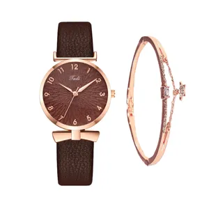 Primo piano di un orologio da donna al quarzo con cinturino in pelle marrone e bracciale.