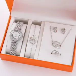 Dettaglio di un set di gioielli e orologio da donna in strass con design a doppio cuore.