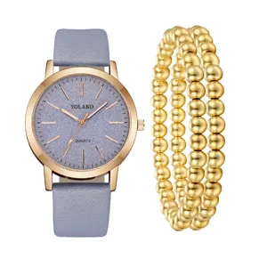 Vista dettagliata dell'orologio da donna con cinturino grigio e perle dorate.