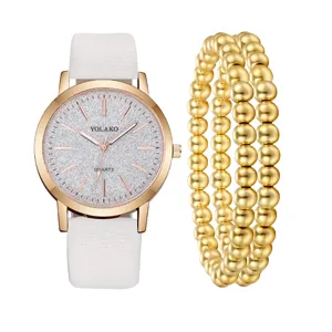 Orologio al quarzo da donna e set bracciale con perle d'oro, cinturino in pelle bianca e quadrante.