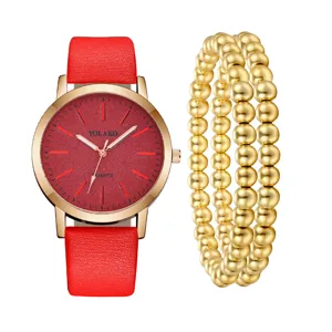 Vista dettagliata di un orologio al quarzo con cinturino in pelle rossa e bracciale dorato.