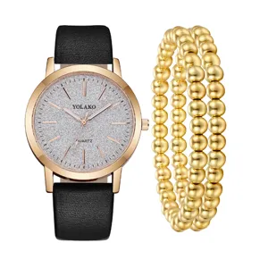 Set orologio al quarzo da donna con cinturino in pelle nera e bracciali di perle dorate.
