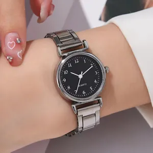 Primo piano di un orologio al quarzo da donna con quadrante nero rotondo e cinturino in metallo.