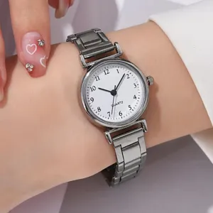 Primo piano di un orologio al quarzo da donna con cinturino in metallo grigio e quadrante bianco.