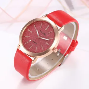 Primo piano del quadrante glitterato rosso, cassa dorata e cinturino in pelle elegante.