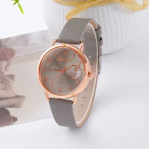 Primo piano dell'elegante orologio al quarzo con cinturino grigio e quadrante oro rosa.
