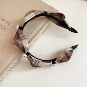 Brown plaid fabric headband close-up, elegant pearl embellished hair accessory detail shot.