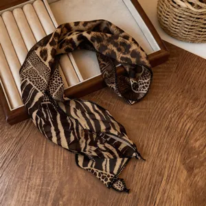 Λεπτομερής λήψη κομψού φουλάρι με animal print, μοτίβα λεοπάρ και ζέβρας σε ξύλο.