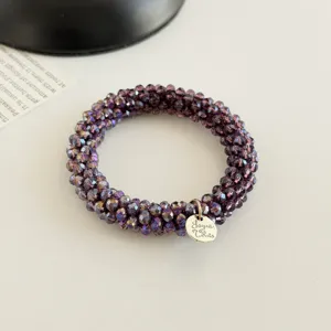 Exquisites Kristallperlen-Haargummi und Armband Detail, elegantes violettes Haaccessoire.