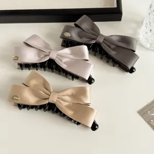 Gedetailleerd shot van de satijnen strik haarklem, elegant haaraccessoire in chique kleuren.