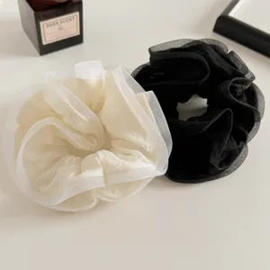 Detailopname van de elegante mesh haarband met fijne geruffelde randstructuur.