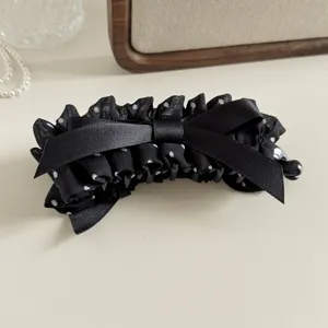 Exquisite black polka dot hair claw clip with satin bow, elegant accessory for women and girls.