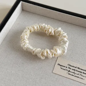 Elegantes weißes Satin Haargummi, weiche seidenähnliche Textur für bequemes tägliches Styling.